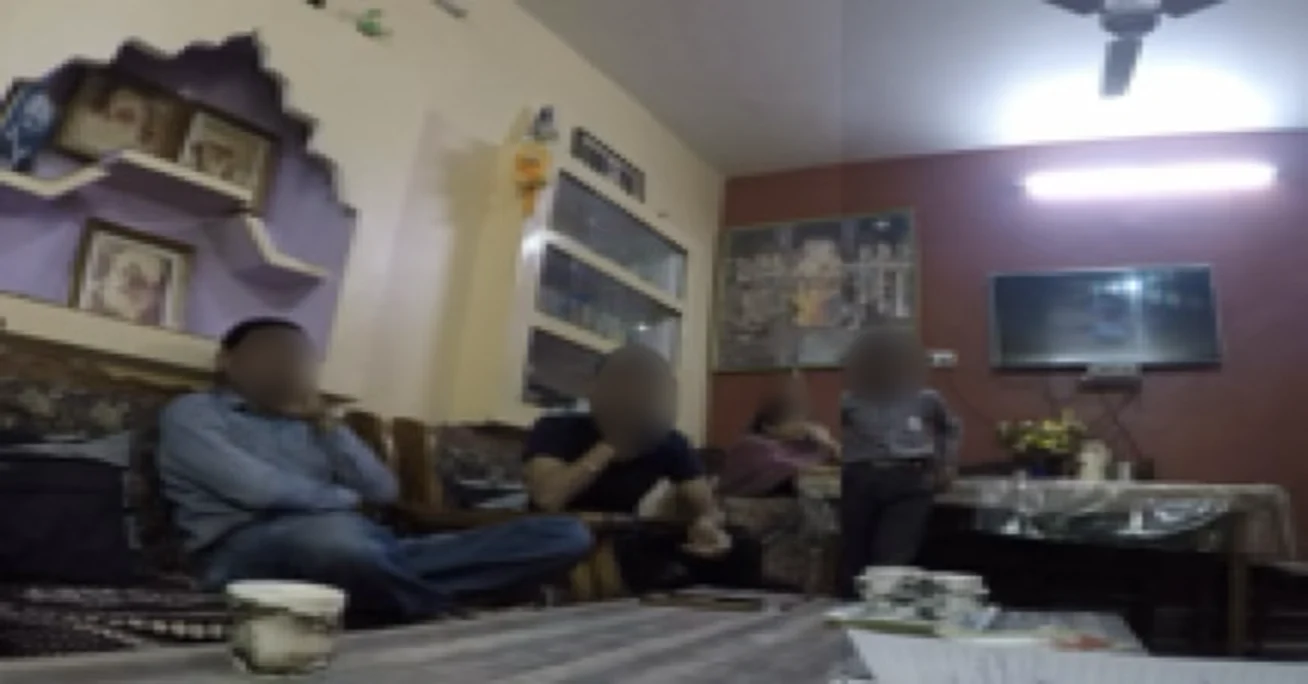 Diary photo of a family watching TV together in their living room, faces obscured